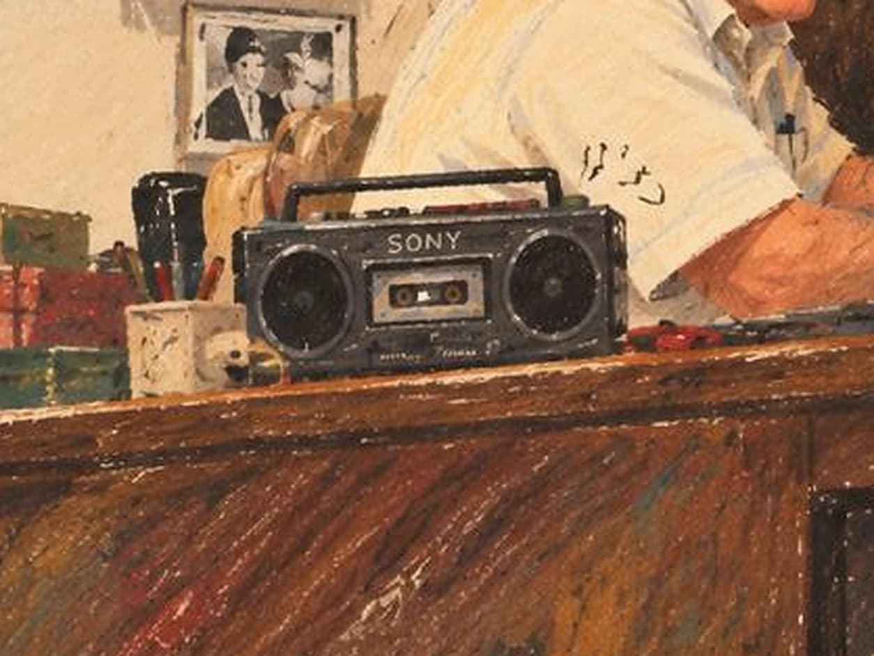 An old radio on the counter beside framed photographs at the clock shop